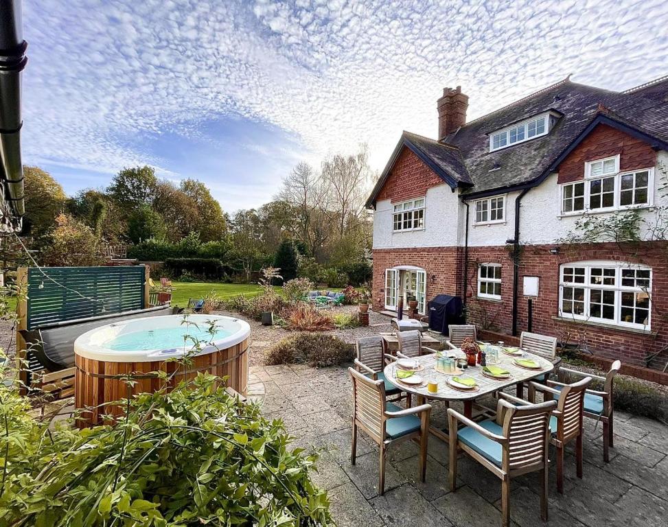 eine Terrasse mit einem Tisch und Stühlen sowie einem Whirlpool in der Unterkunft Tiger Hall in Church Stretton