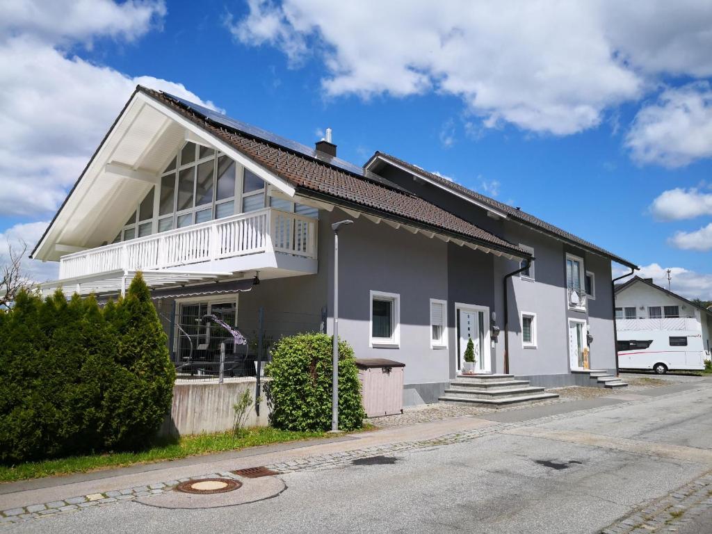 ein weißes Haus mit Balkon auf einer Straße in der Unterkunft Ferienwohnung Neuerer in Riedlhütte