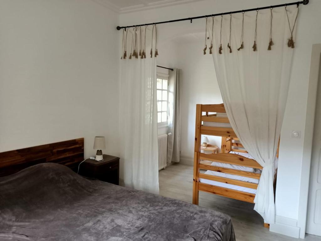 a bedroom with a bed and a chair and a window at Moulin les Forges gîte 12 places avec piscine chauffée en Périgord in Gavaudun
