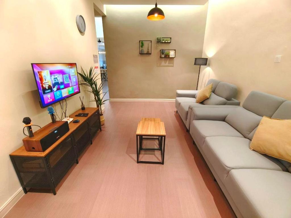 ein Wohnzimmer mit Couch und Flachbildfernseher in der Unterkunft Gateway Sri Klg 11pax KTV Neflix Water Machine Town in Keluang