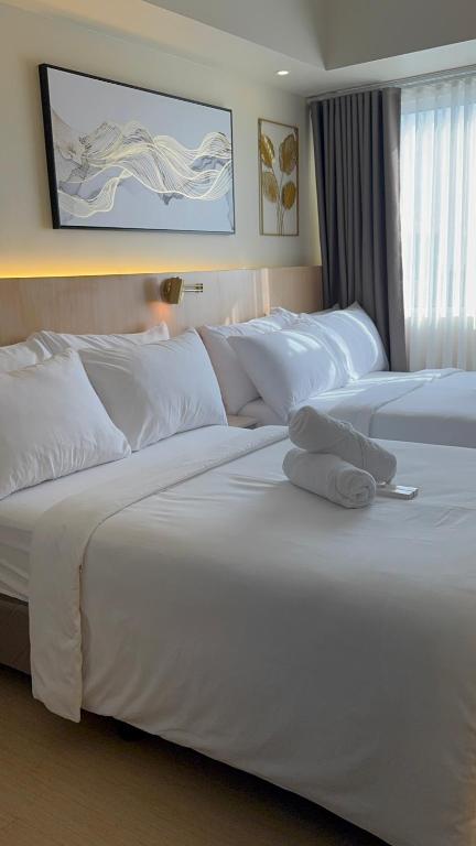 a hotel room with two beds with white pillows at Cattleya BNB Rentals 1 at Avida Tower 2, CDO in Cagayan de Oro