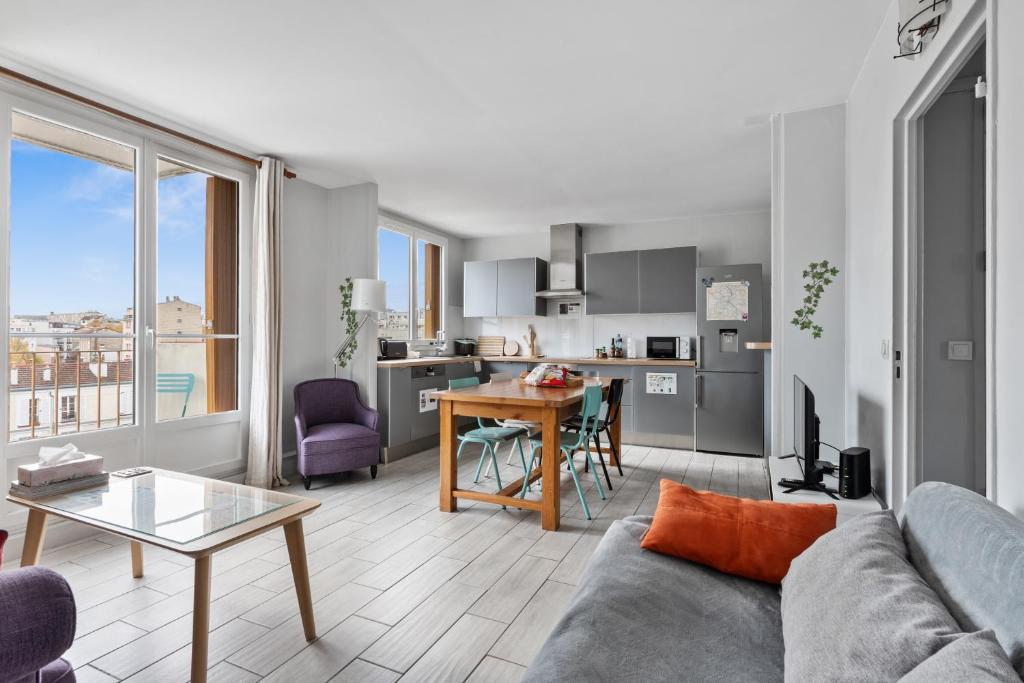 ein Wohnzimmer mit Sofa und Tisch in der Unterkunft Cosy in Paris in Vanves