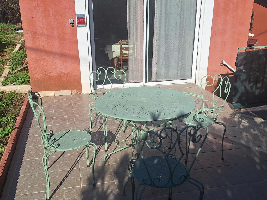 a green table and two chairs on a patio at l'oasis in La Farlède