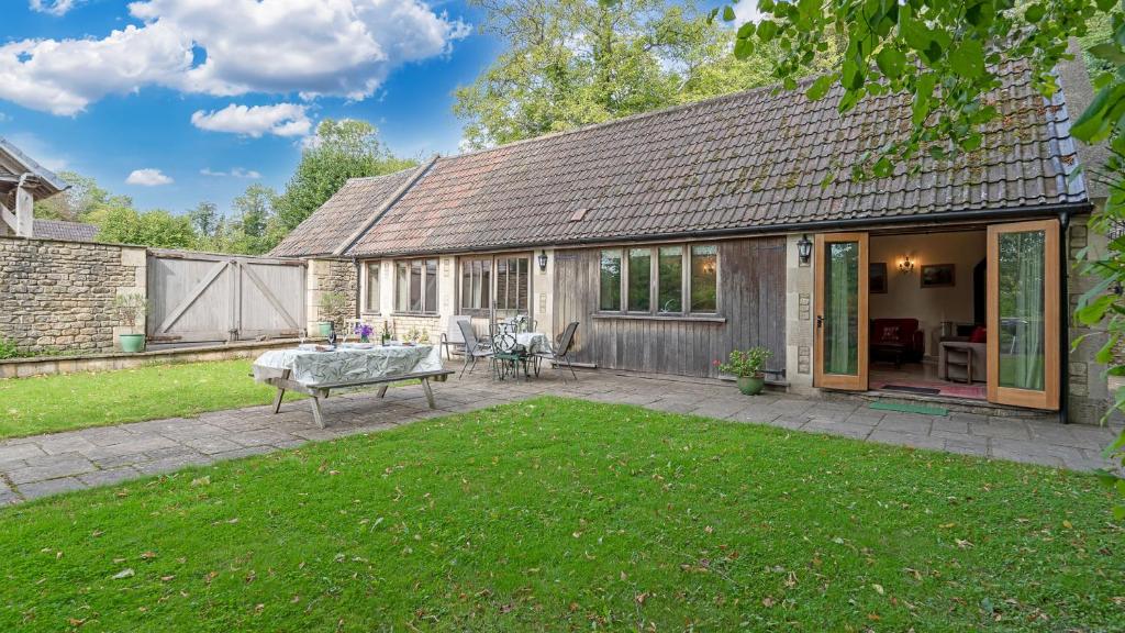 a house with a patio and a yard at The Stables, Batheaston in Batheaston
