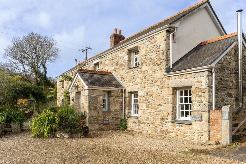 een oud stenen huis met een tuin ervoor bij Beryas Cottage in Newlyn
