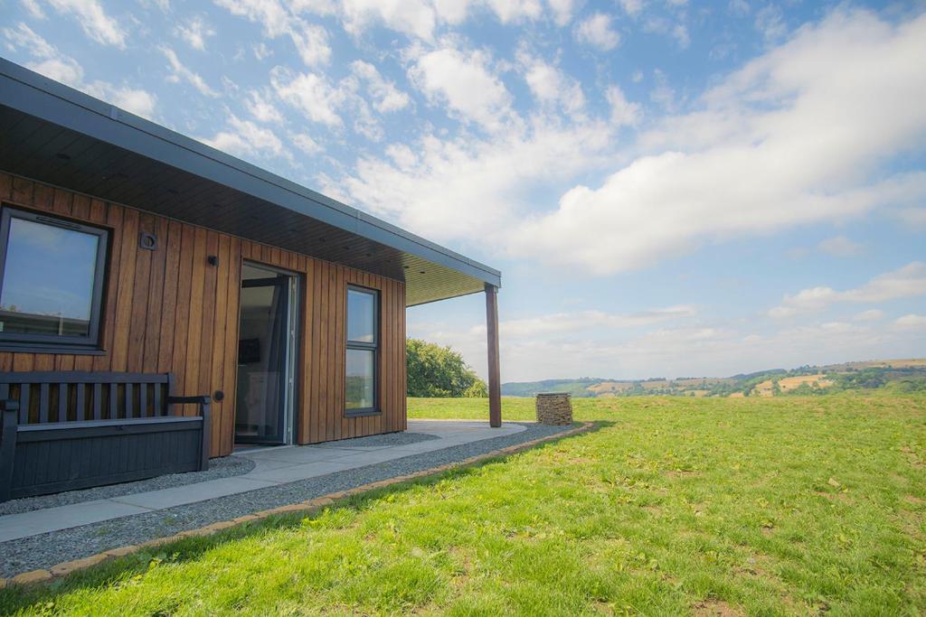 WirksworthThe Outside-Inn Wirksworth的一座木屋，旁边有一大片田野