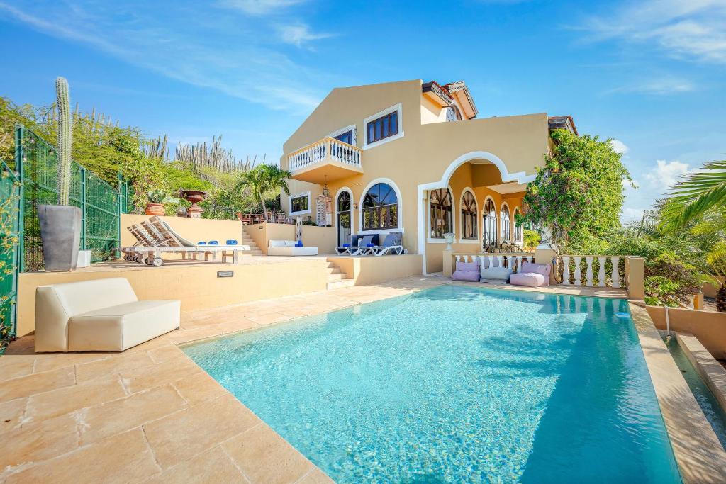 eine Villa mit einem Swimmingpool vor einem Haus in der Unterkunft Jamanota Villa 4BR Mansion with Infinity Pool in Noord