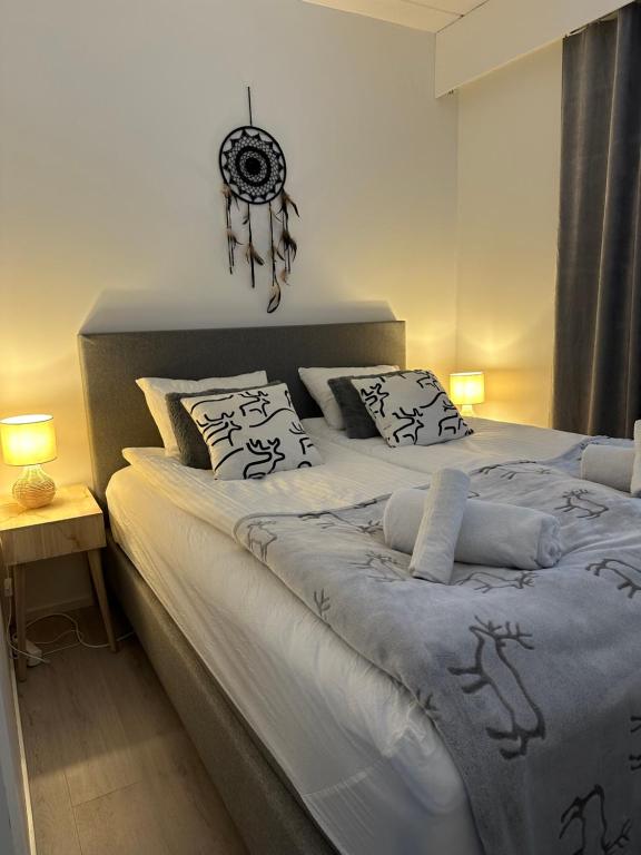 a bedroom with a large bed with white sheets and pillows at Apartment Ahkiomaantie in Rovaniemi