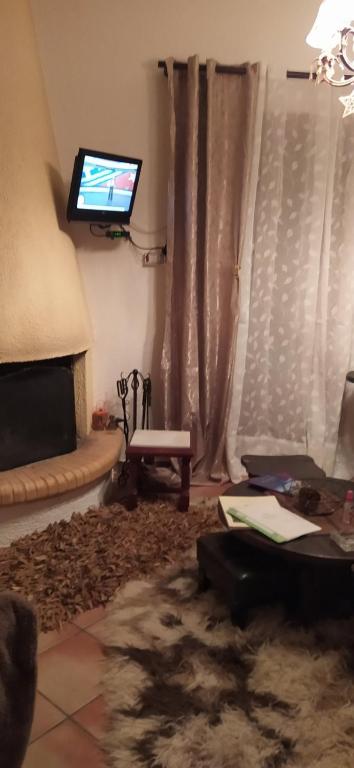 a living room with a couch and a tv on the wall at ΑΡΣΙΝΟΗ apartments1 in Arachova
