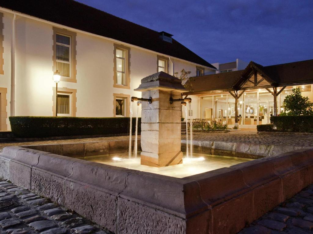 a water fountain in front of a house at Novotel Saclay in Saclay