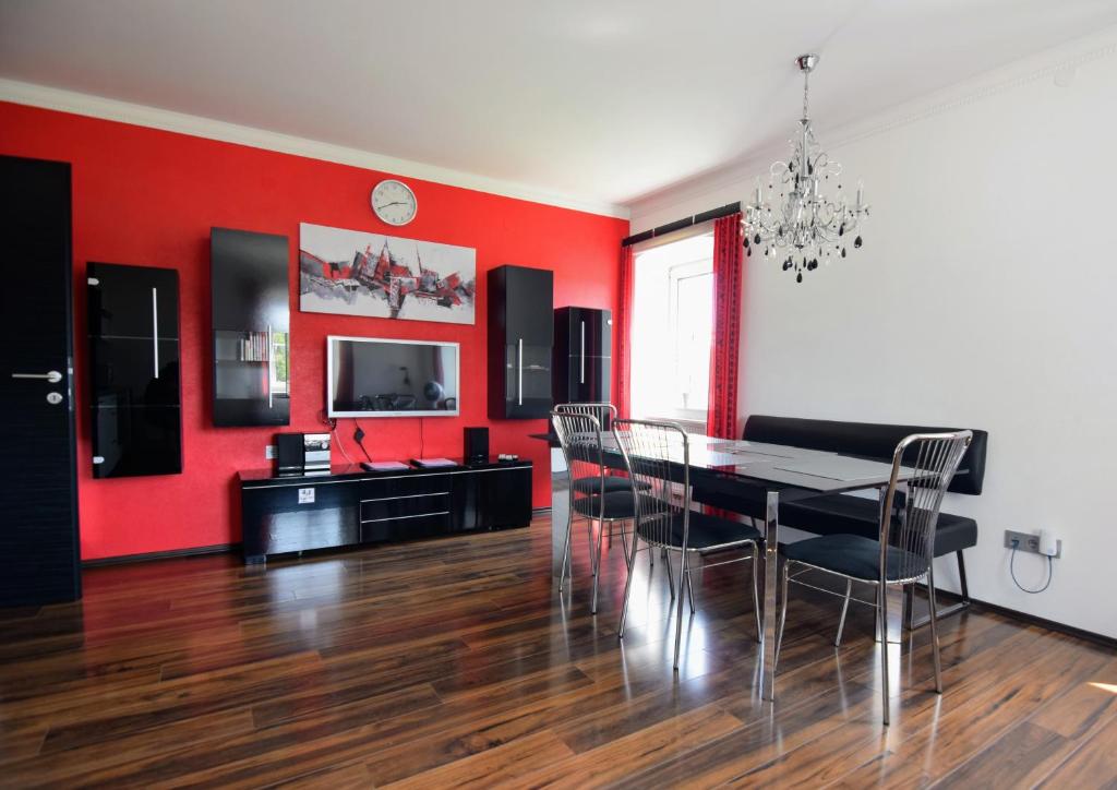 ein Esszimmer mit roten Wänden sowie einem Tisch und Stühlen in der Unterkunft Bauernhof erleben Stilvolle 120 m Ferienwohnung im Mostviertel in Kniebichl