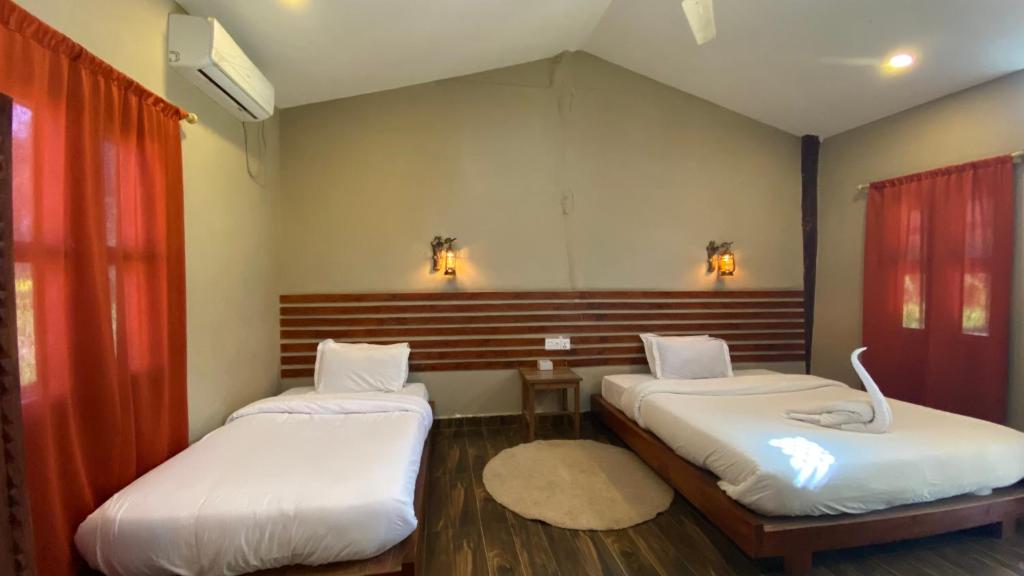 a room with two beds in a room at Sauraha Tharu Village in Sauraha