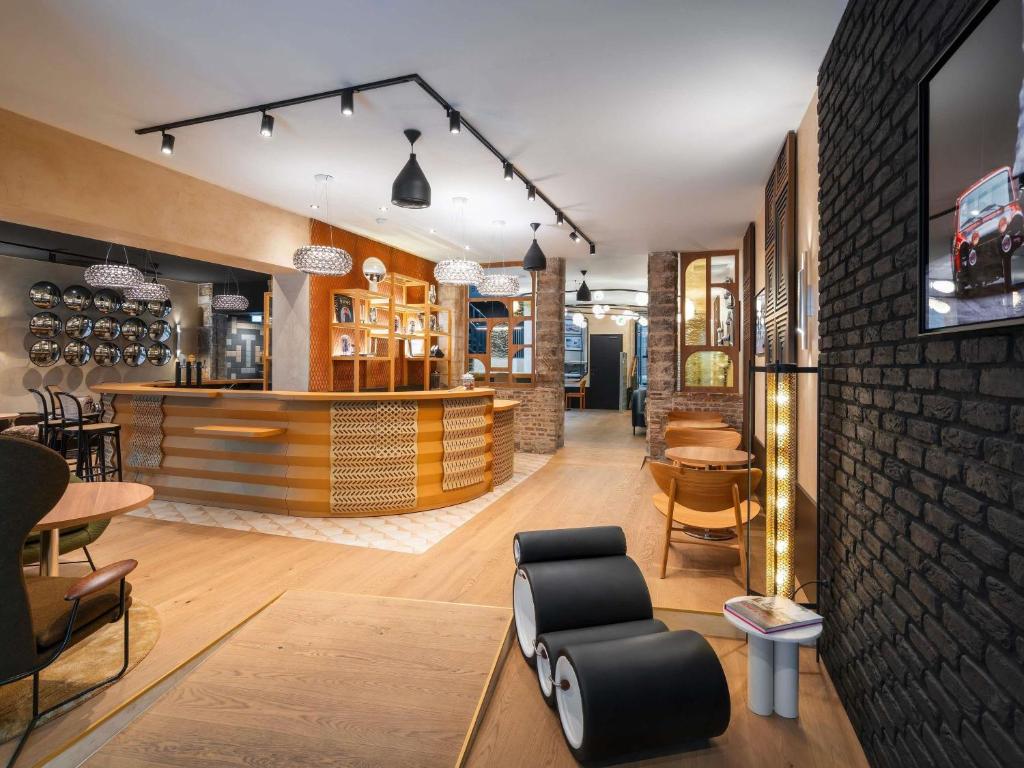 a restaurant with a bar with a chair and tables at Hotel Maison Louise Lille Centre - Handwritten Collection in Lille
