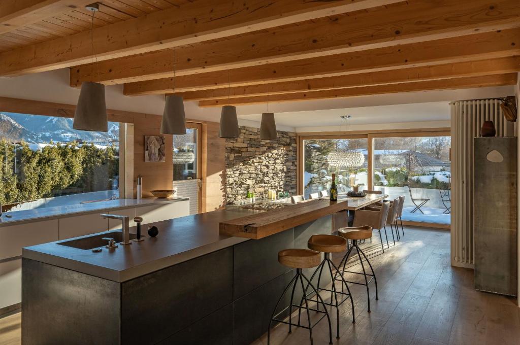 una cocina con una encimera grande con taburetes. en Chalet Sendlhofer, en Bad Hofgastein