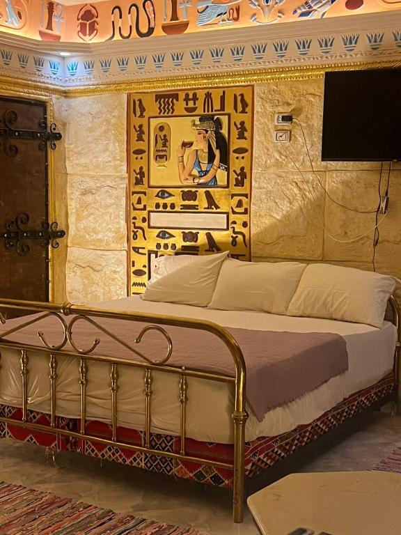 a bed in a room with a painting on the wall at Pyramids Mystery Inn in Cairo