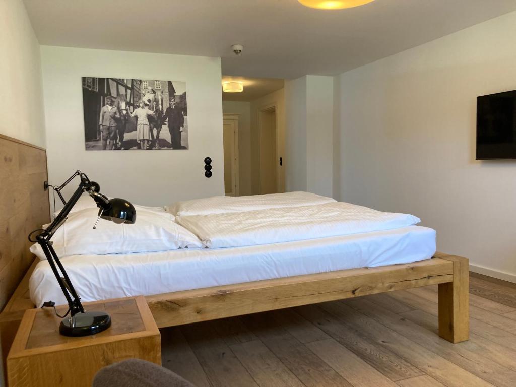 a bedroom with a bed and a desk with a lamp at Hof Hallenberg in Hallenberg