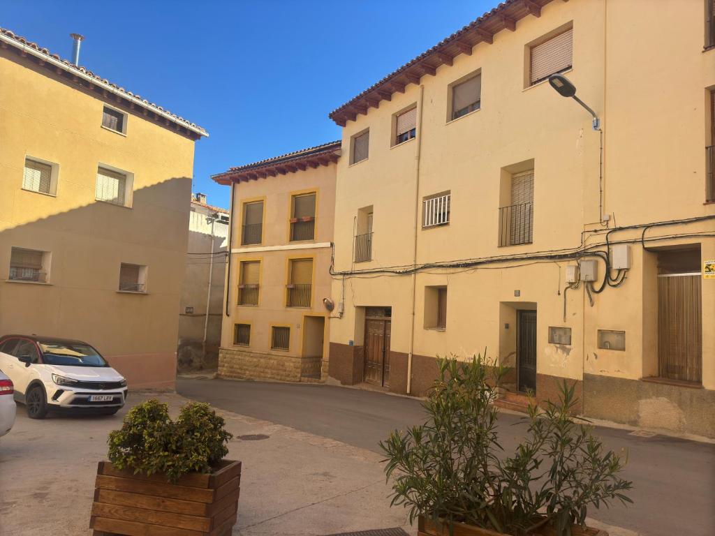 a street with two buildings and a car parked at Hostal Marcela Berge in Berge