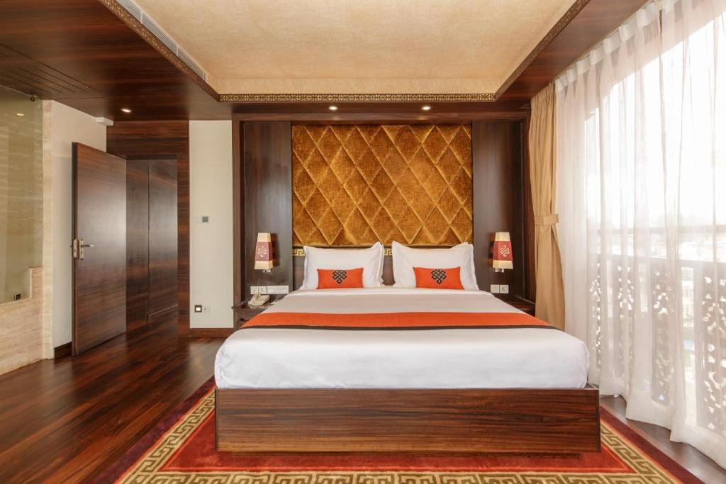 新德里Hotel The L D Casa Near International airport的一间卧室，配有一张大床和一扇大窗户。