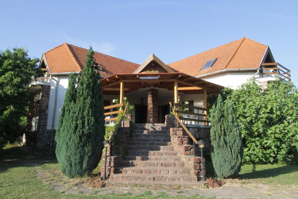 a house with a staircase in front of it at Vöröskő apartmanház in Révfülöp