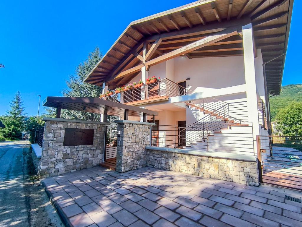 una casa con camino in pietra e balcone di Maria Luisa Mountain Lodge a Rovere