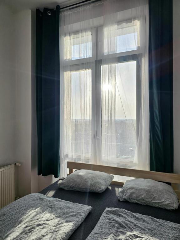 a bedroom with two beds and a window at W1 PRIVATE rooms in Krakow