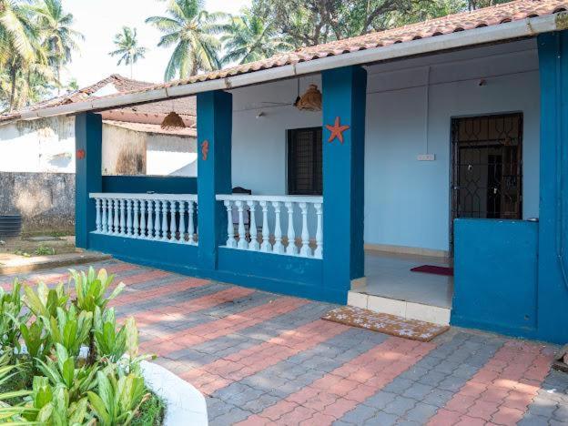 AgarvadoAbigail serene stay的蓝白色房子,背后有棕榈树