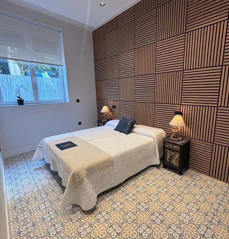 a bedroom with a bed and two lamps and a window at Alojamiento EL ESPOLON in Alba de Tormes