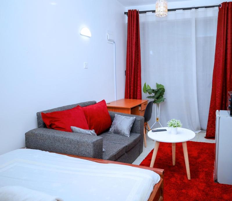 a living room with a couch and a table at Studio in Roysambu with a study desk in Nairobi