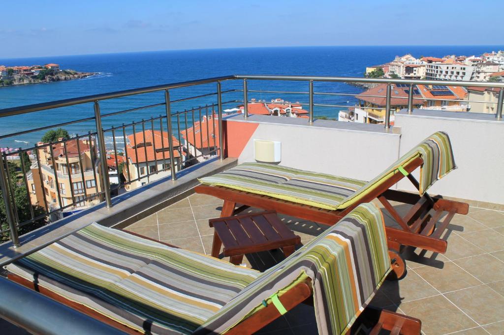 een balkon met een tafel en stoelen en de oceaan bij Family Hotel Radiana in Sozopol