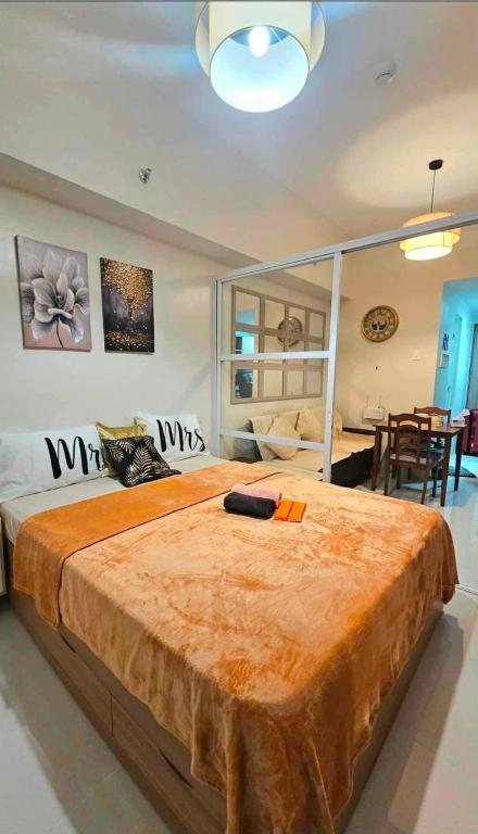 a bedroom with a large bed and a dining room at Primeworld District with Balcony near Mactan Airport in Pajak