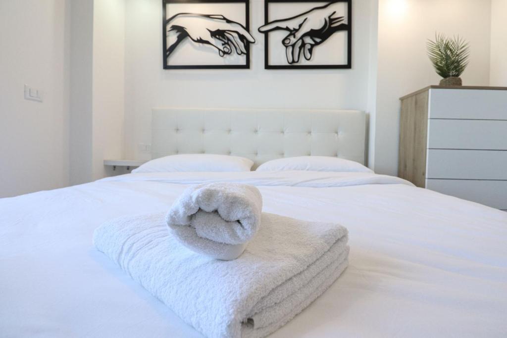 un letto bianco con un asciugamano bianco di Masi House a La Massimina-Casal Lumbroso