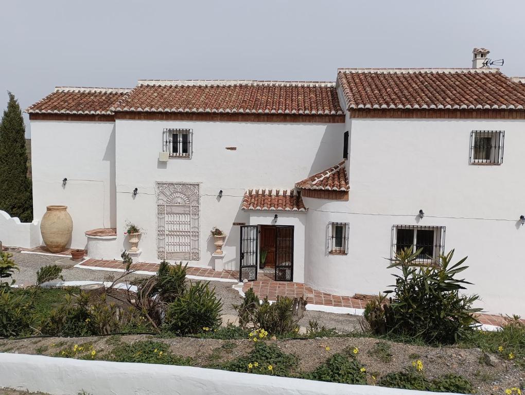 a white house with red tile roofs at villa el almendro in Carratraca
