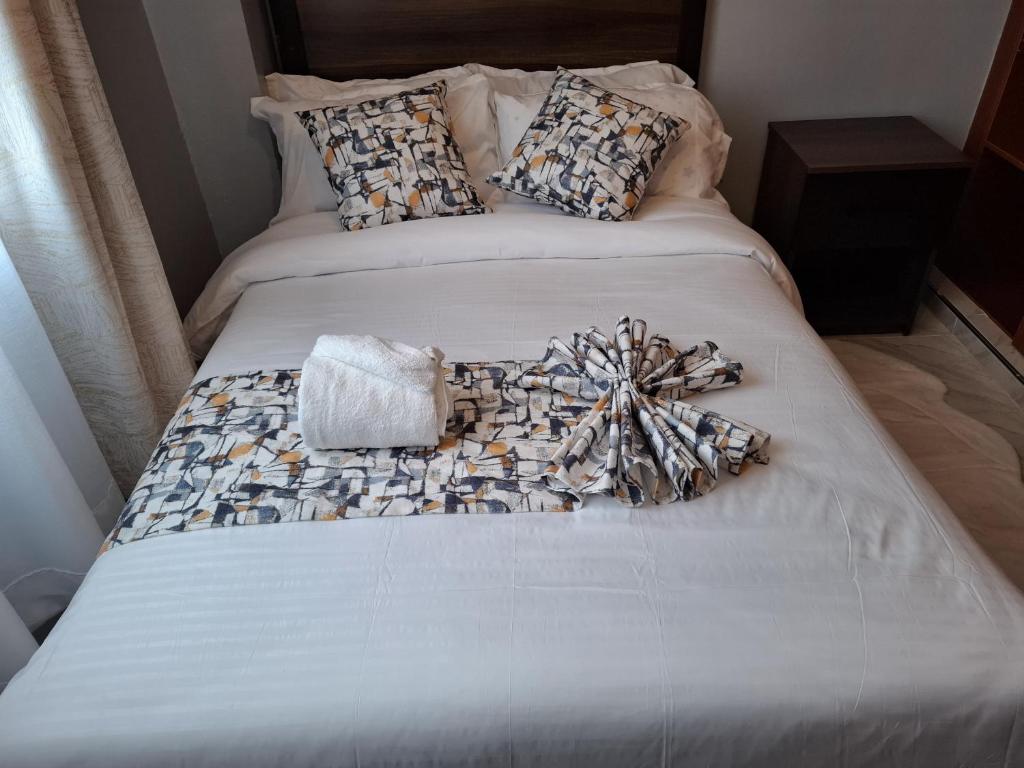 ein Bett mit einer Decke mit einer Schleife darauf in der Unterkunft Still&Simple in Nanyuki