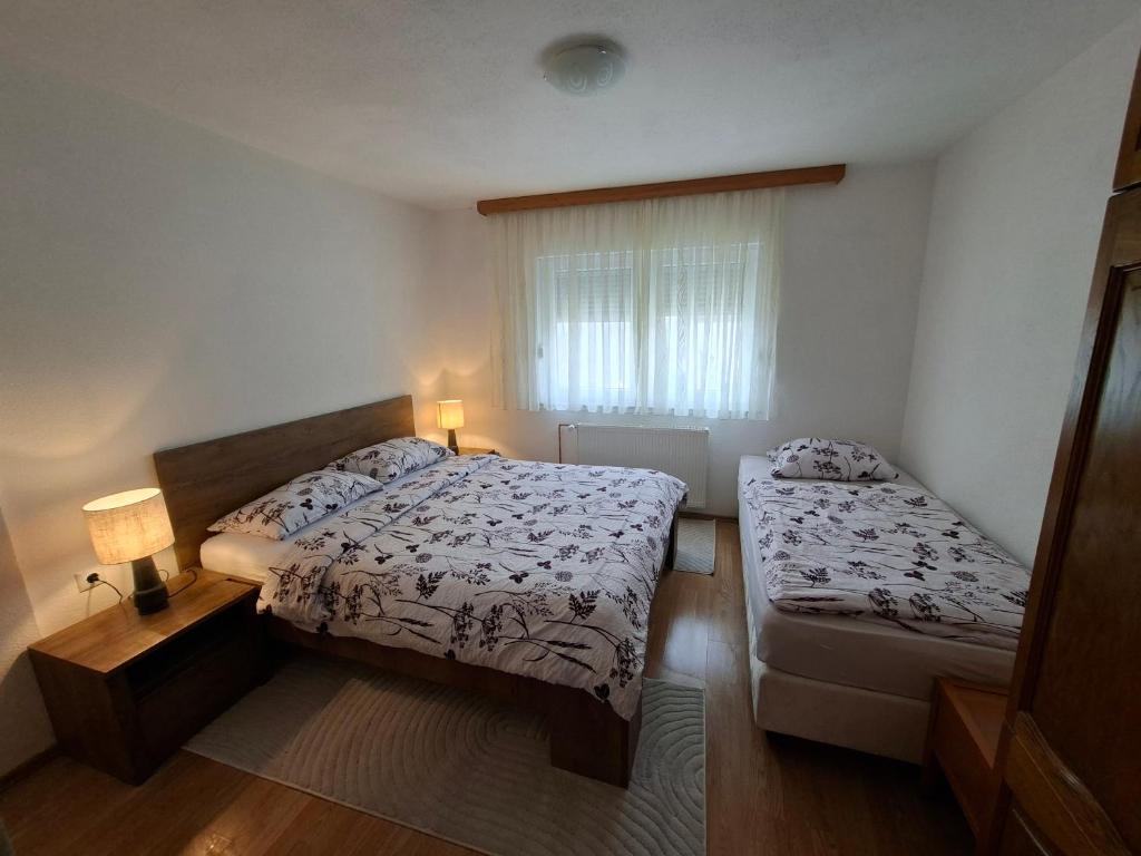 ein kleines Schlafzimmer mit zwei Betten und einem Fenster in der Unterkunft Jakiland house Plitvice Lakes in Korenica