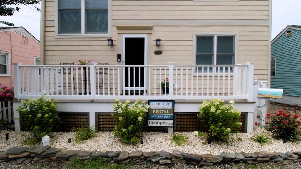a house with a white porch and a sign in front at Family Tides in Cape May
