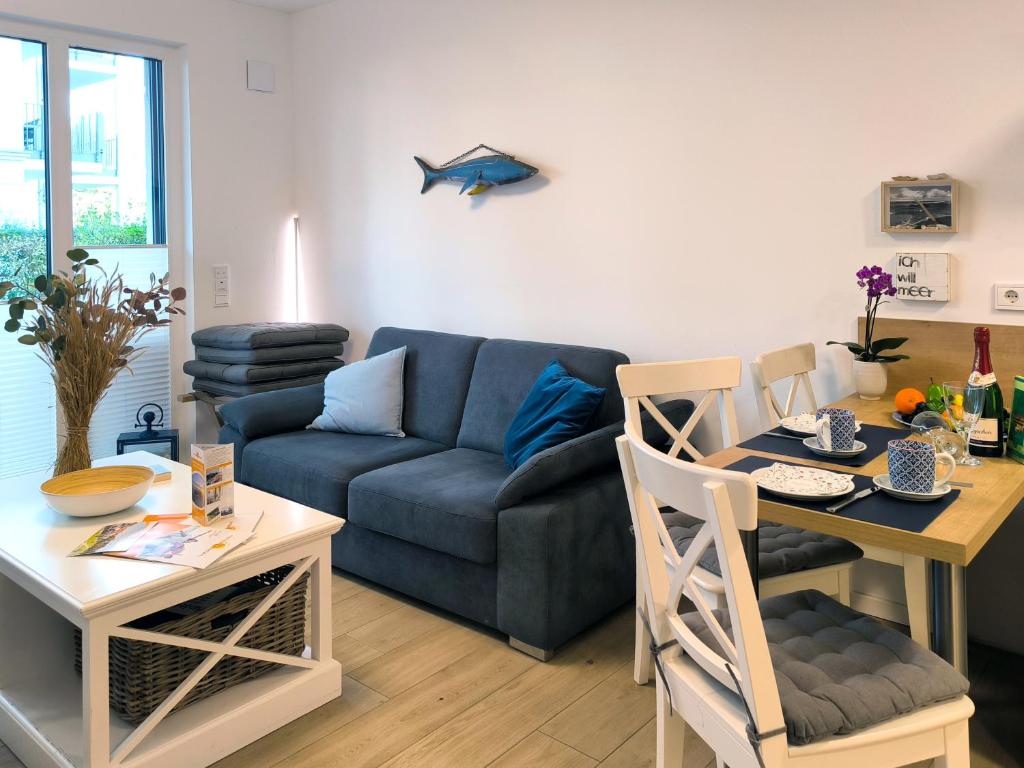 a living room with a blue couch and a table at Baabe Villen-Ensemble FeWo 41 Muschelsucher in Baabe