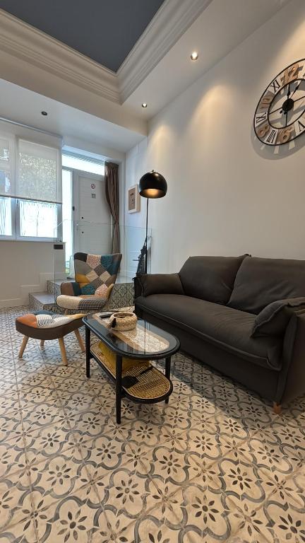 a living room with a couch and a clock on the wall at Alojamiento Lope d vega in Alba de Tormes