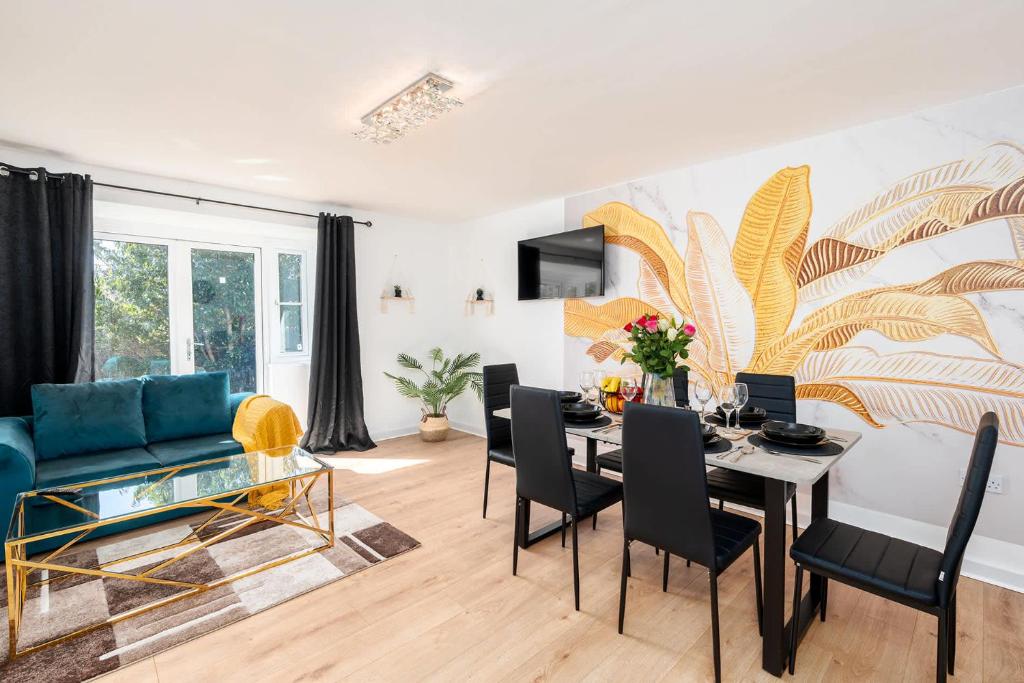 a living room with a table and a blue couch at Spacious 3 Bedroom Home with 6 Beds Private Garden and Driveway Parking in Manor