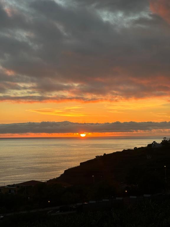 un tramonto sull'acqua con il sole nel cielo di Madeira Mar - "Seaside" a Funchal