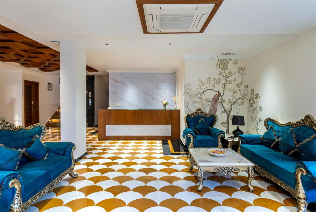a living room with blue couches and a stage at The Classic Crown Udaipur - A Luxury Hotel by Lake Pichola in Jāmb