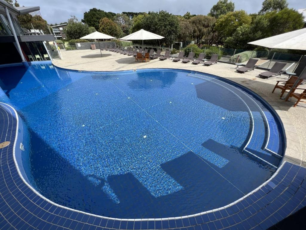 a large blue swimming pool with chairs and umbrellas at Sanny Side Up in San Remo
