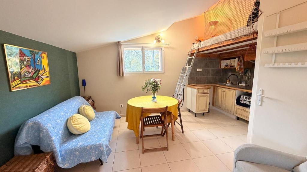 TaulignanProvençal Getaway Pool Studio Hiking的客厅里有一张蓝色的沙发和一张桌子