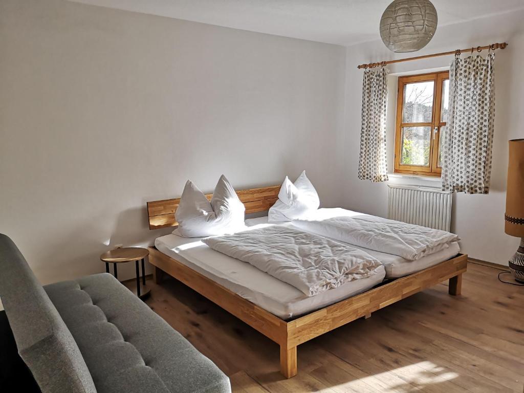 a bedroom with a bed and a couch and a window at Appartement Panoramablick in Grattersdorf