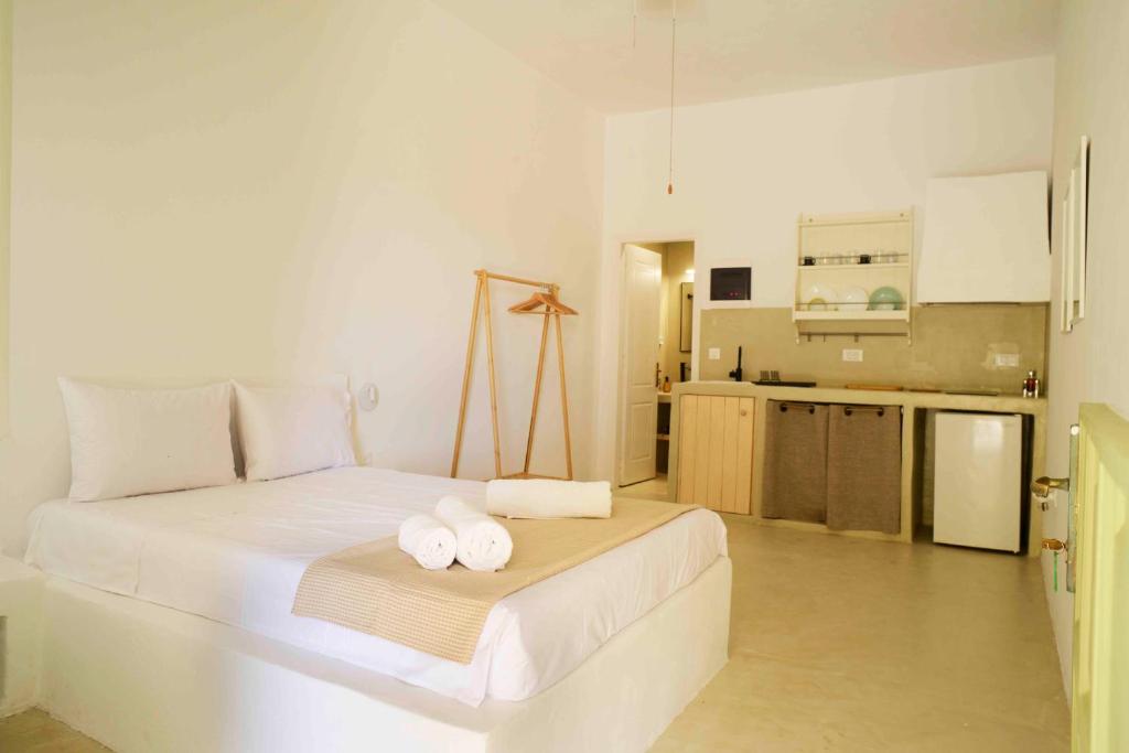 The endless blue hide out في إيوس خورا: غرفة نوم بيضاء مع منشفتين على سرير