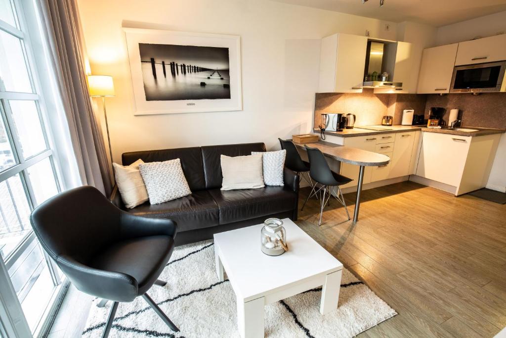 a living room with a couch and a table at Residenz am Balmer See - Kleine Auszeit - BS 21 mit Wellnessbereich in Balm