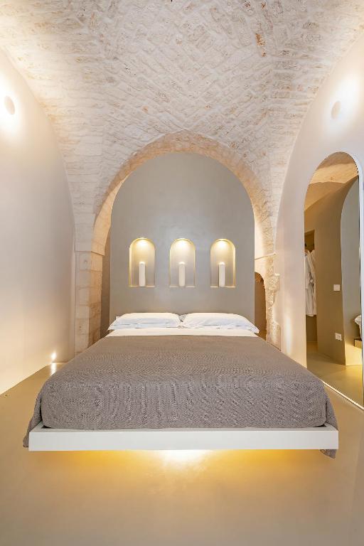een slaapkamer met een groot bed in een witte kamer bij Casalis Luxury Room in Ostuni
