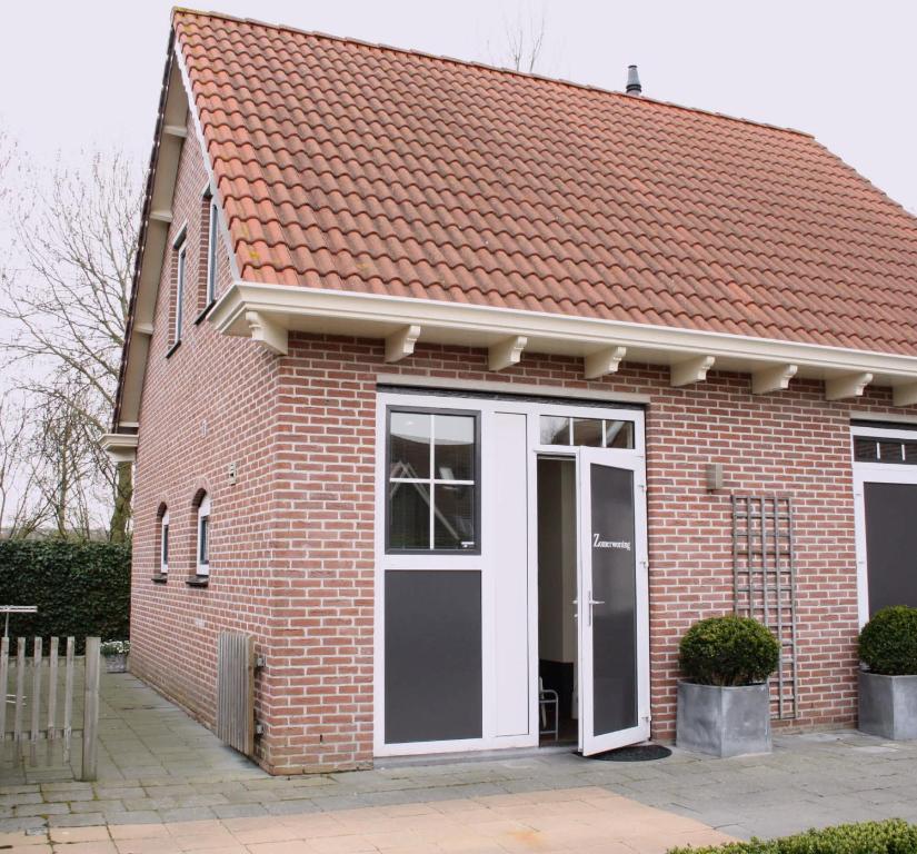 a red brick house with a white door at Hello Zeeland - Halve Maanstraat 10 in Oostkapelle