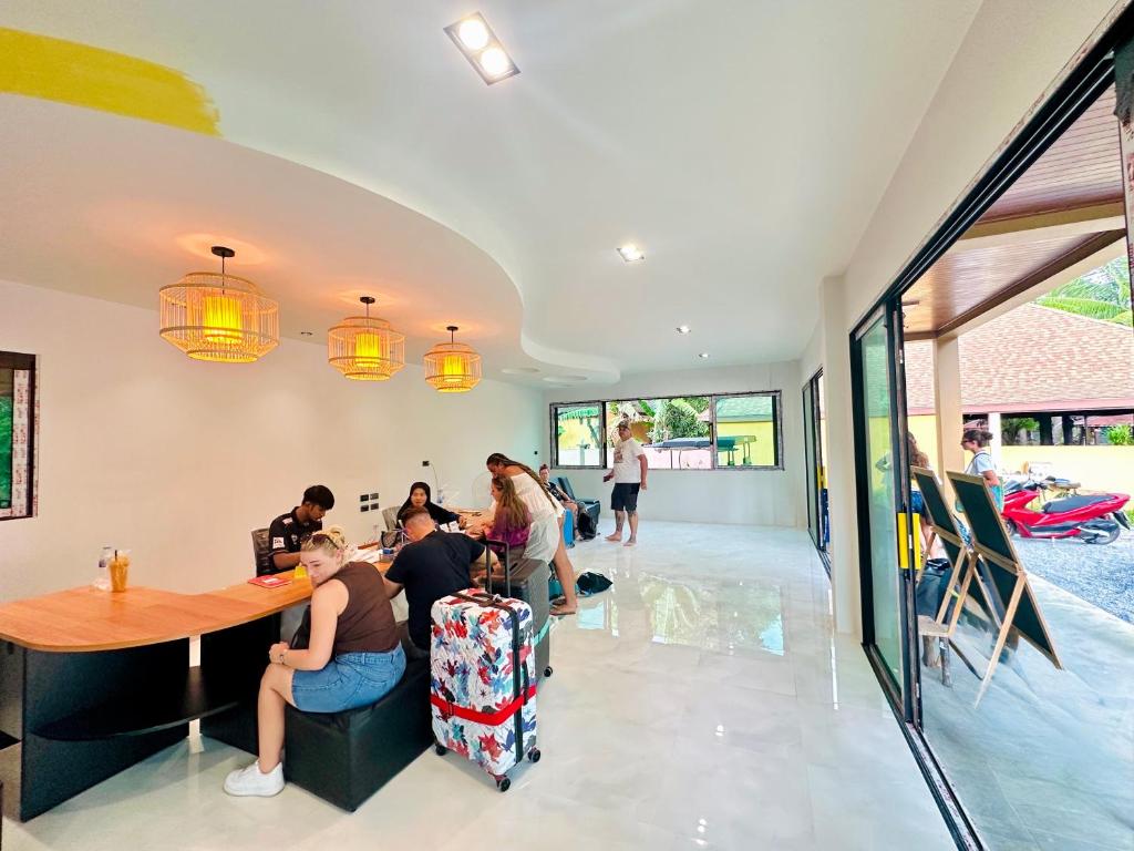 eine Gruppe von Menschen, die an einem Tisch in einem Restaurant sitzen in der Unterkunft Lanta Palm Beach Resort , Beach Bungalow - Koh Lanta in Ko Lanta