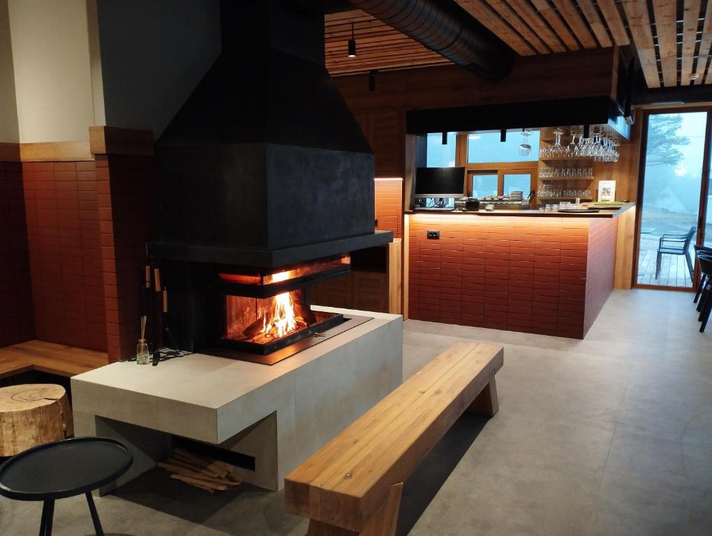 ein Wohnzimmer mit Kamin und Holzbank in der Unterkunft Vila Plamenac in Divčibare