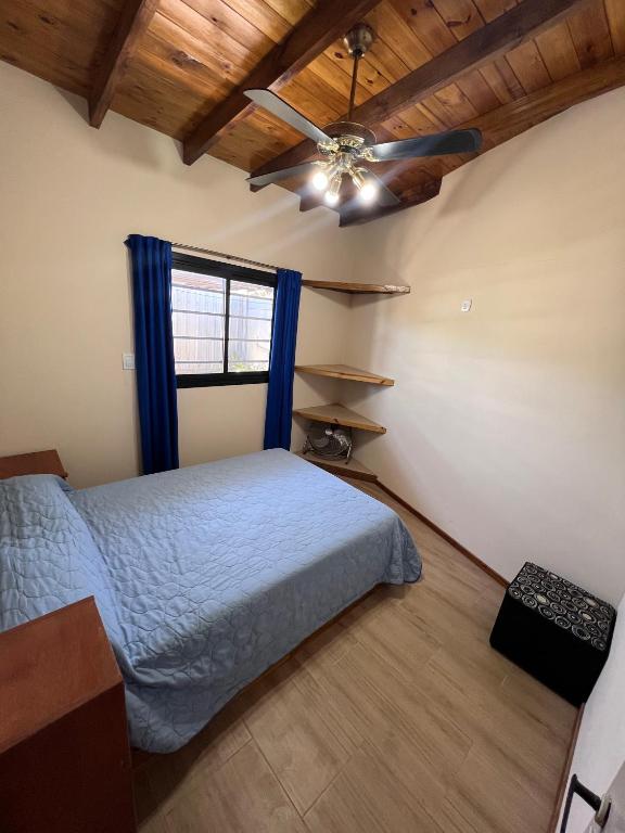 a bedroom with a bed and a ceiling fan at Hospedaje a 2 cuadras de la playa Mar de Cobo in Mar de Cobo